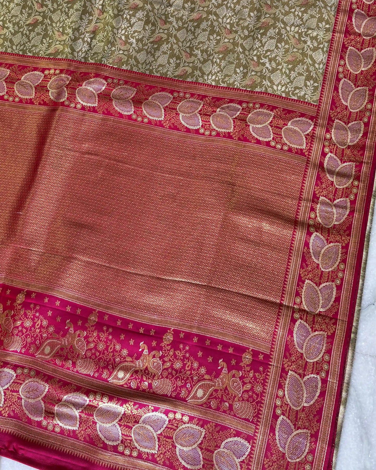 Traditional saree with pink and green patterns on a white background