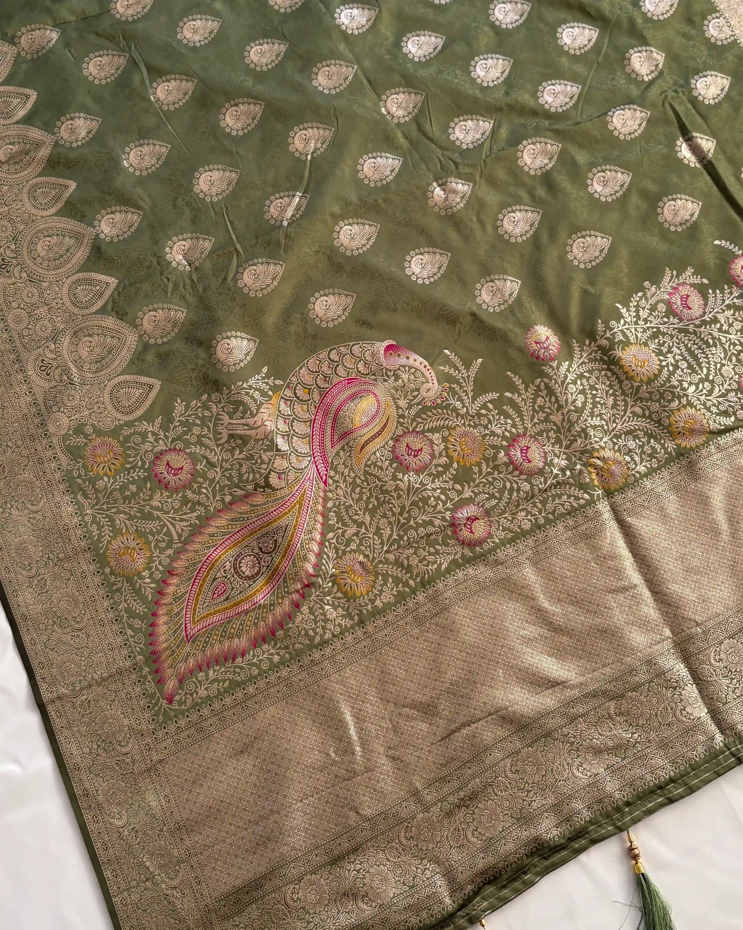 Embroidered fabric with peacock design on a green and beige background