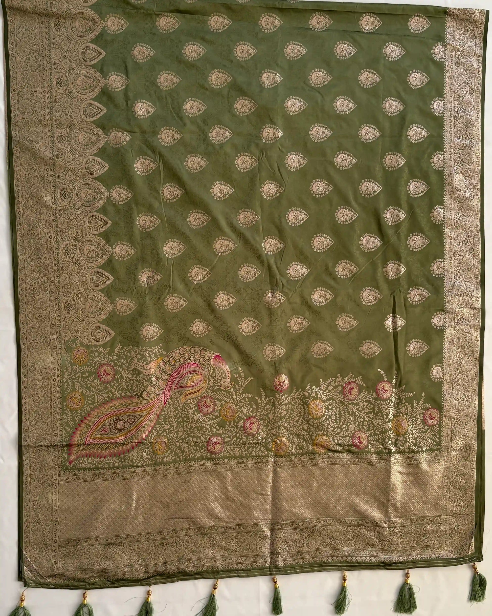 Green and beige embroidered fabric with tassels on a white background