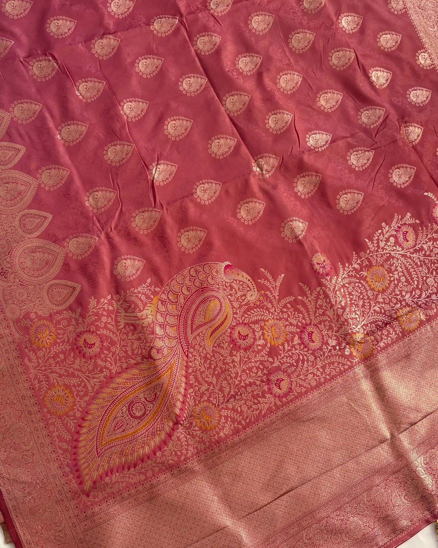 Pink fabric with intricate gold paisley patterns