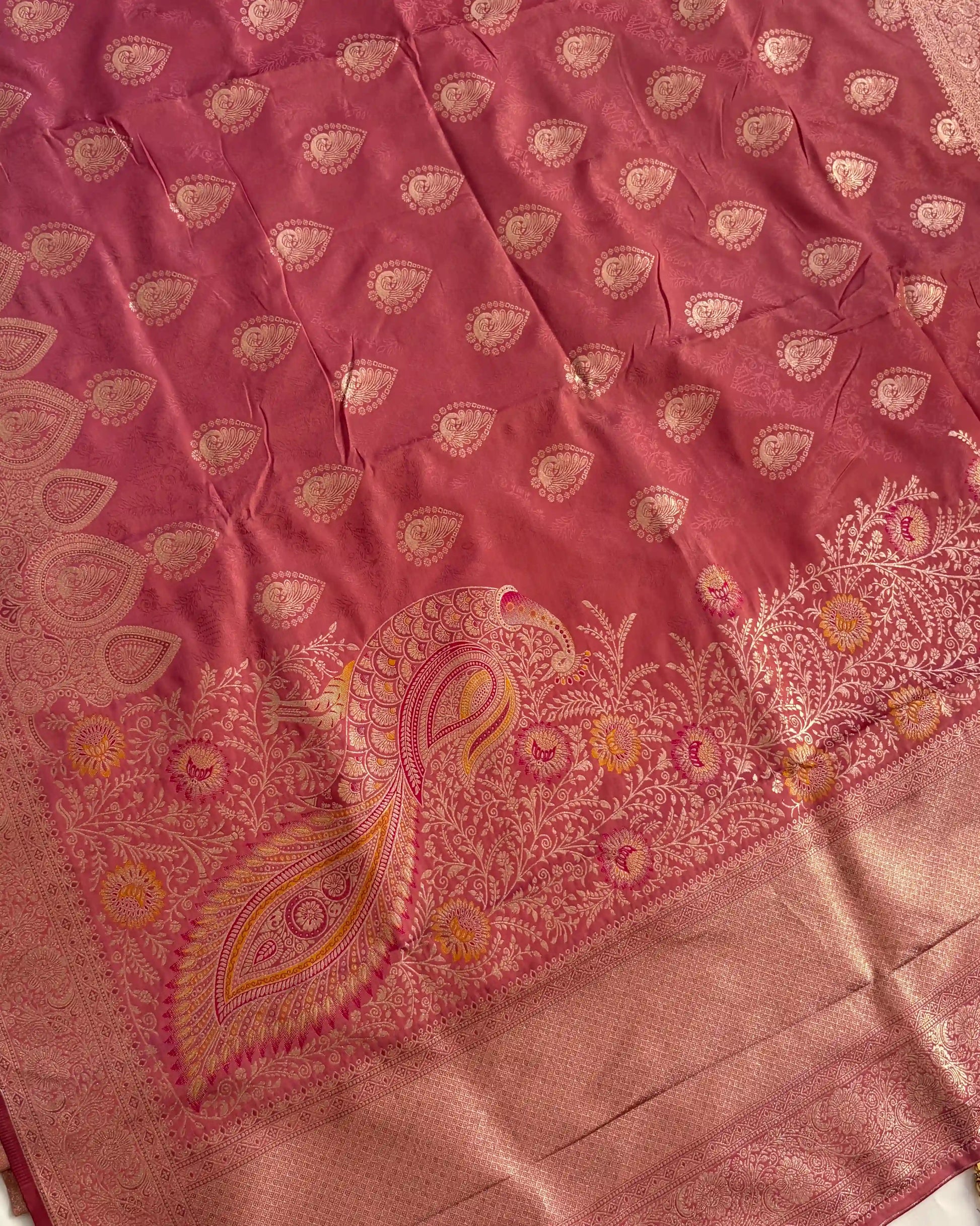 Pink fabric with intricate gold paisley patterns