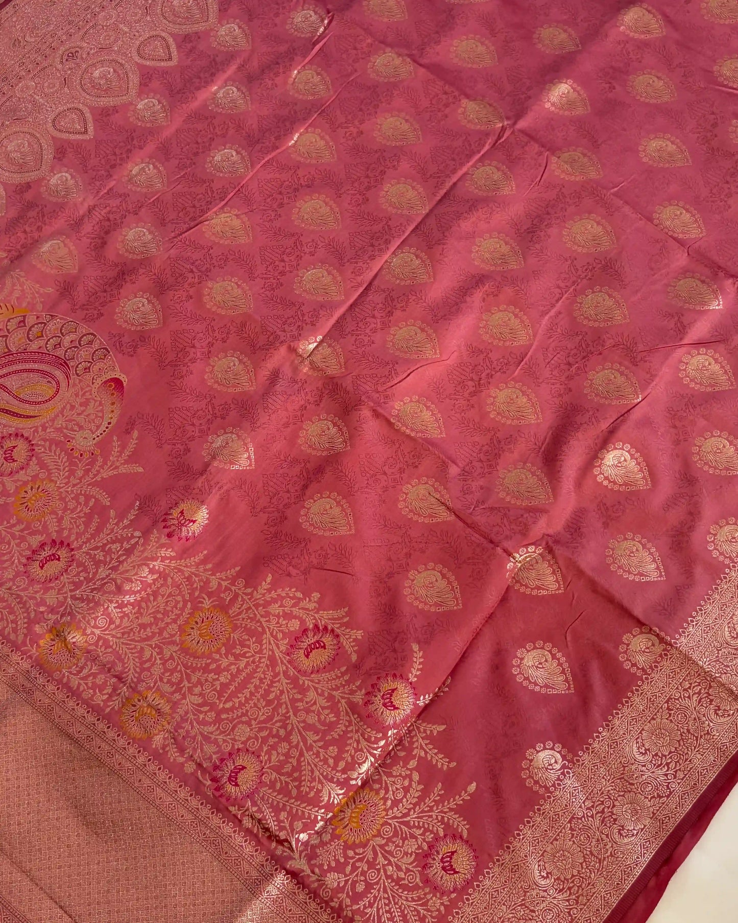 Pink saree with gold patterns on a plain background