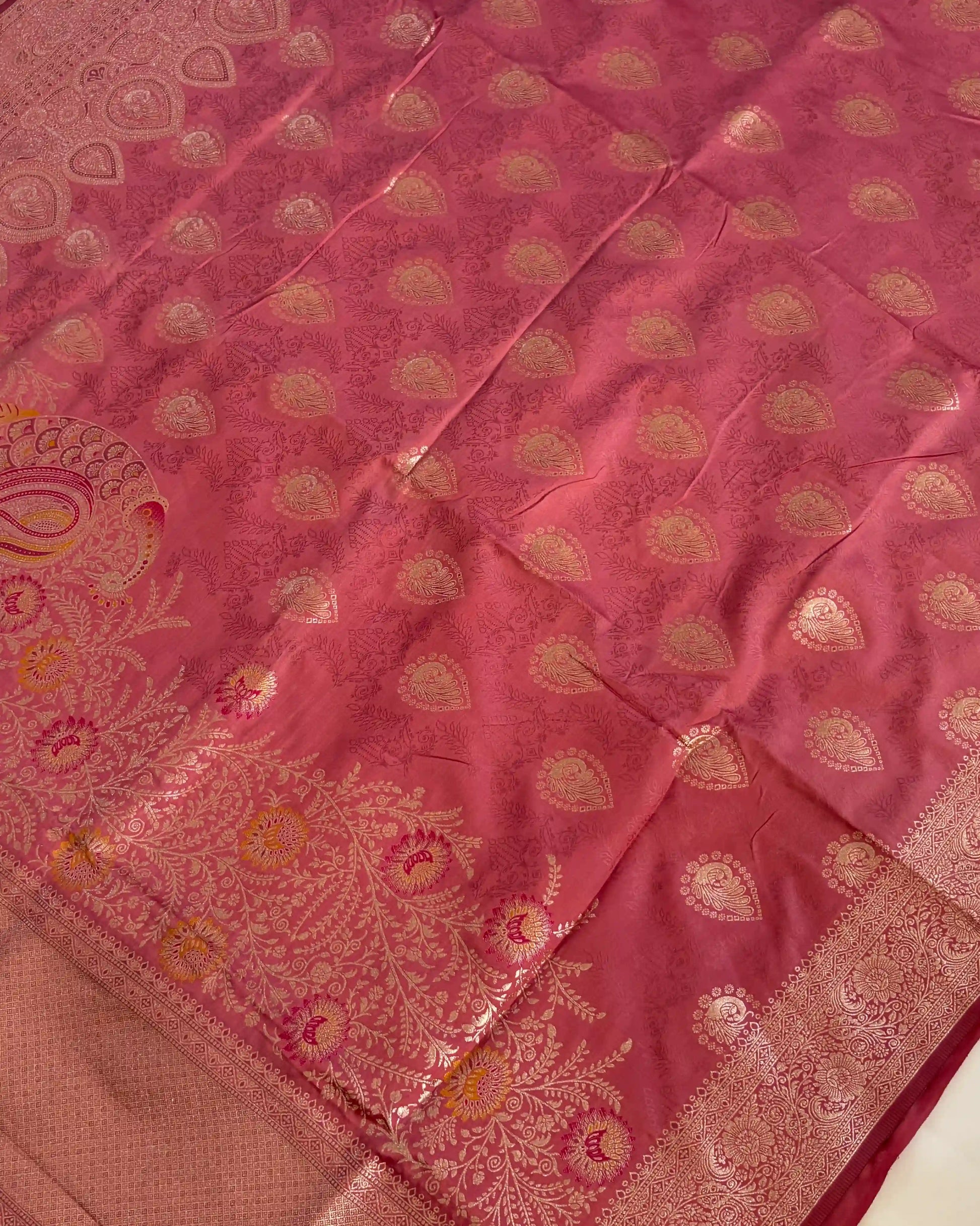Pink saree with gold patterns on a plain background