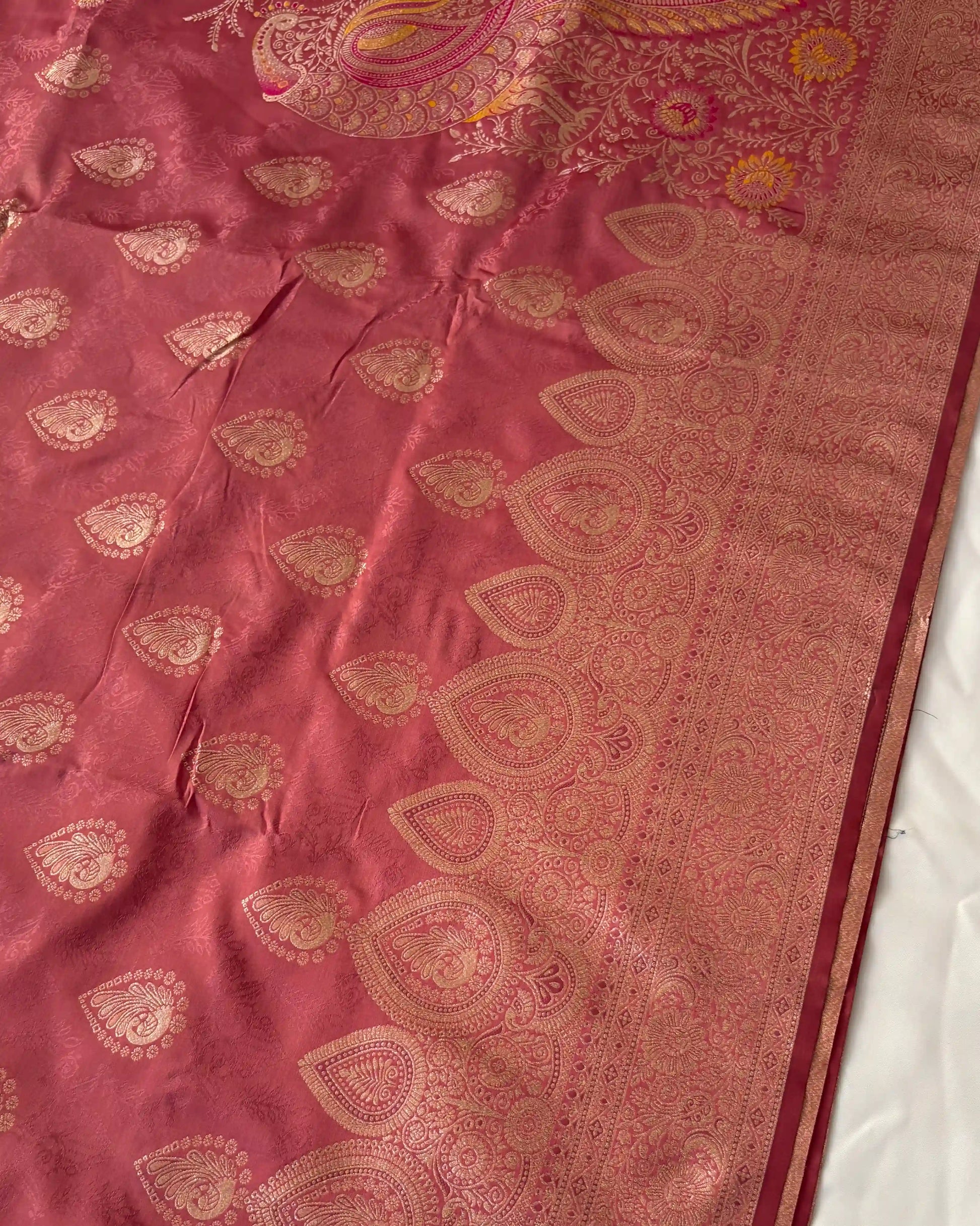 Maroon fabric with gold embroidery on a white background
