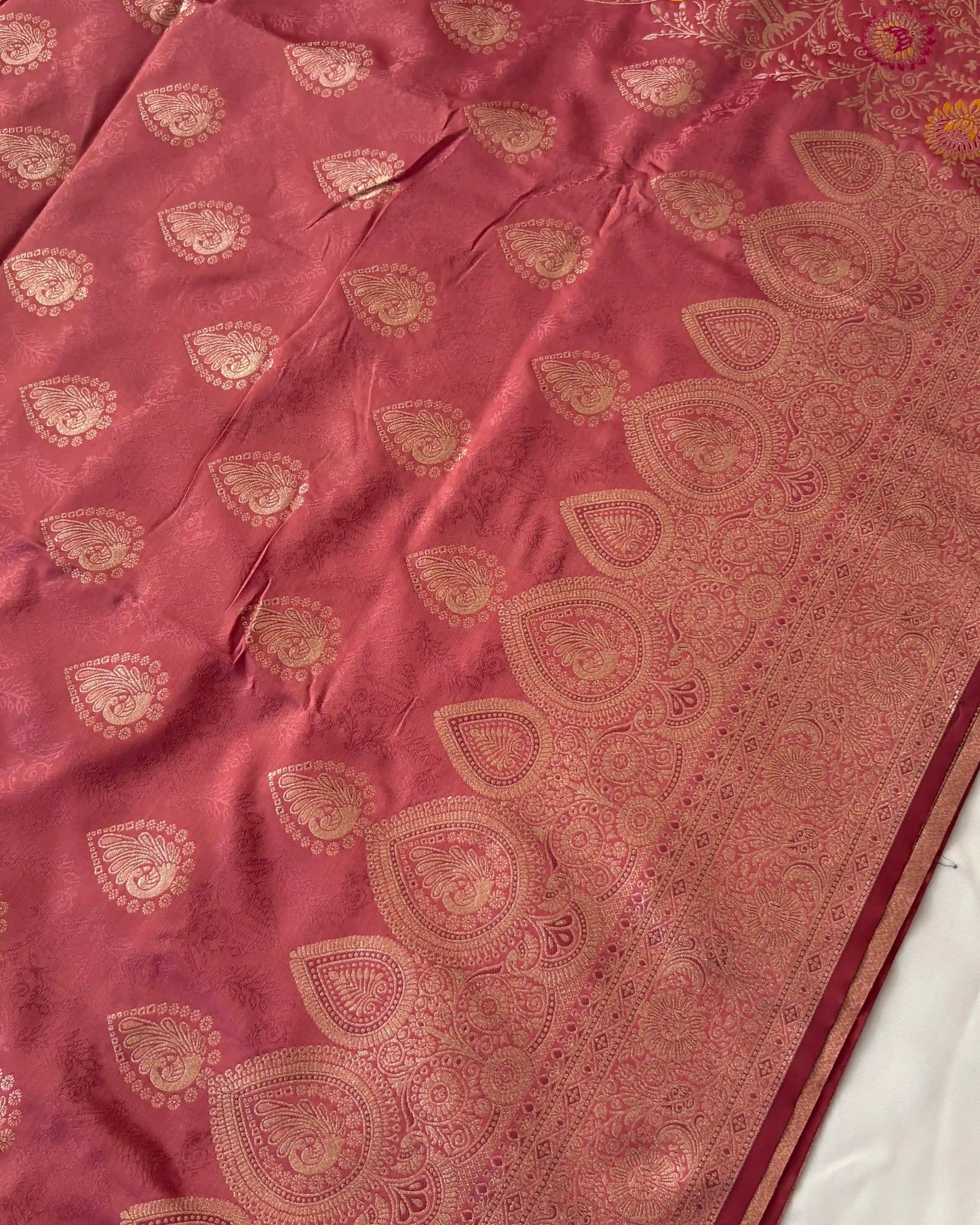 Maroon fabric with gold embroidery on a white background