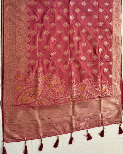 Pink fabric with gold embroidery and tassels on a white background