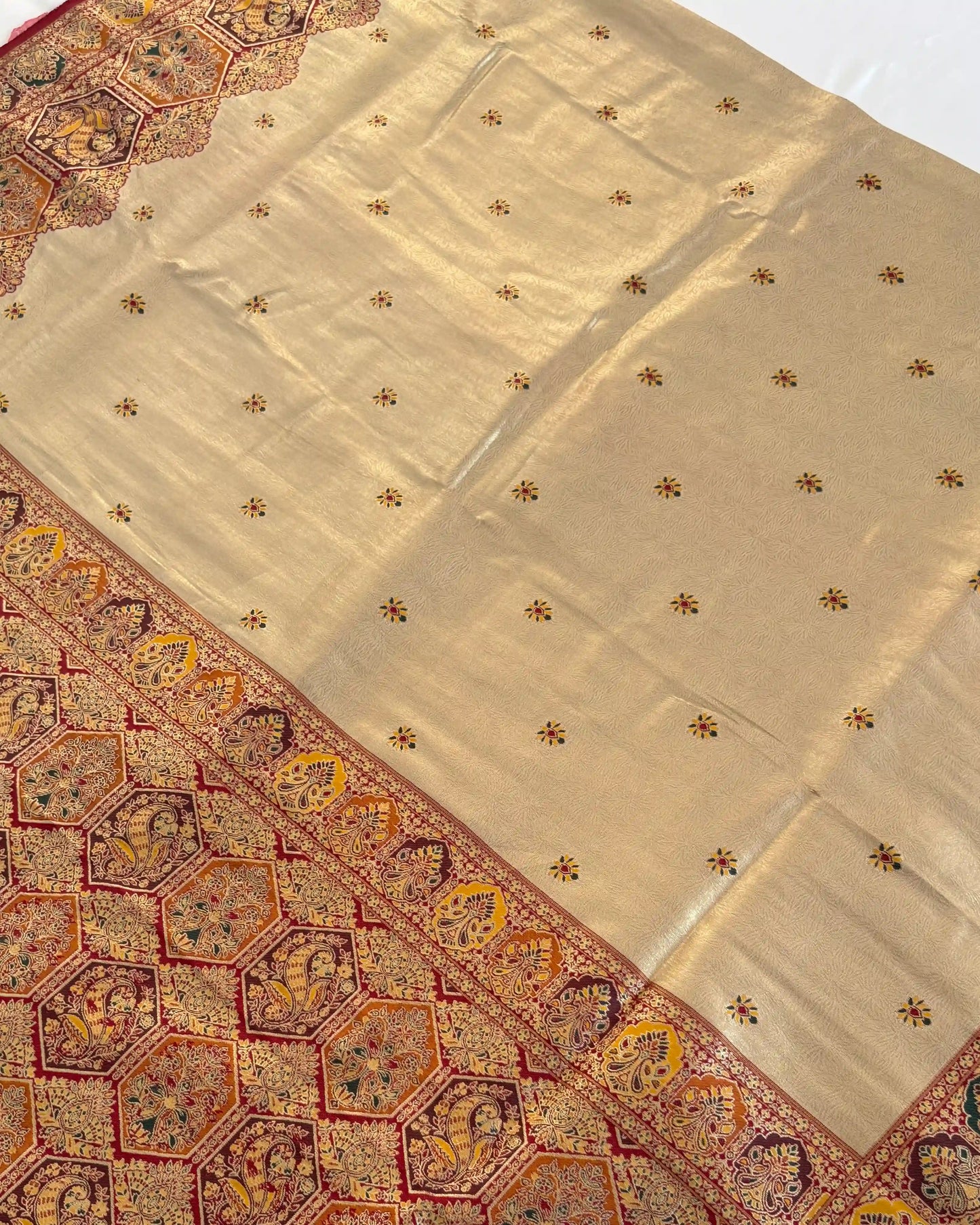 Beige fabric with intricate gold patterns on a white background