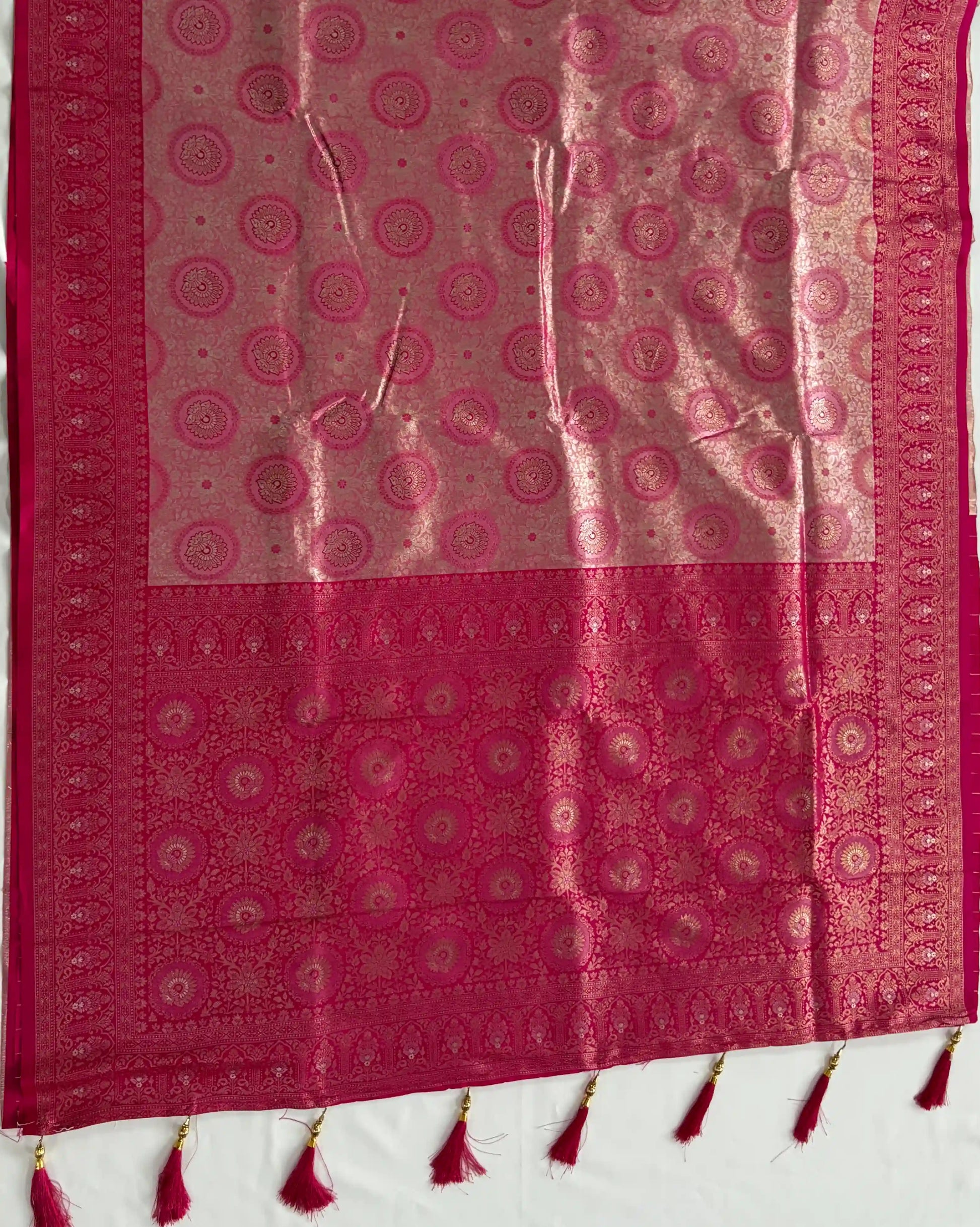 Red and pink patterned fabric with tassels on a white background