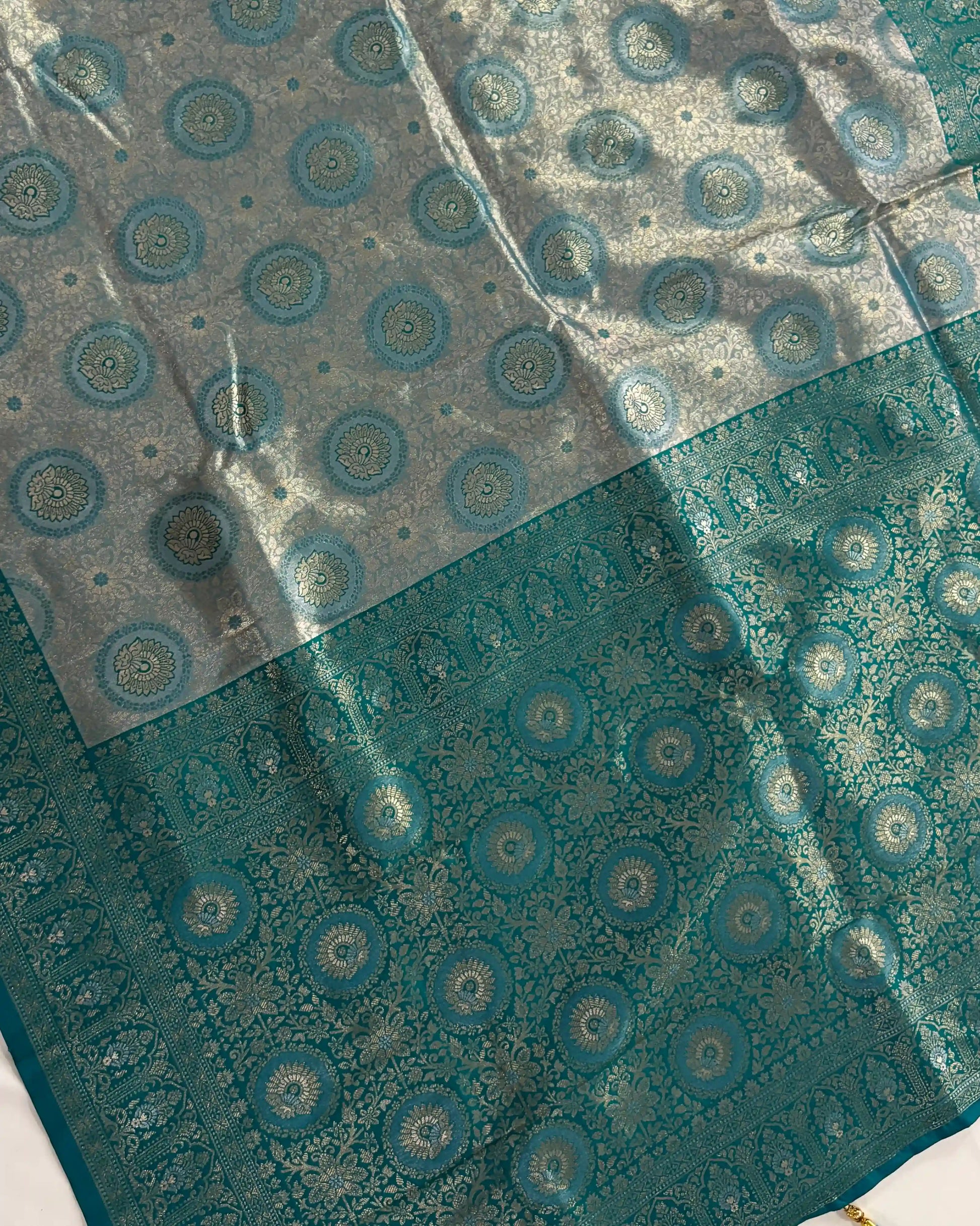 Teal fabric with circular patterns on a clear background