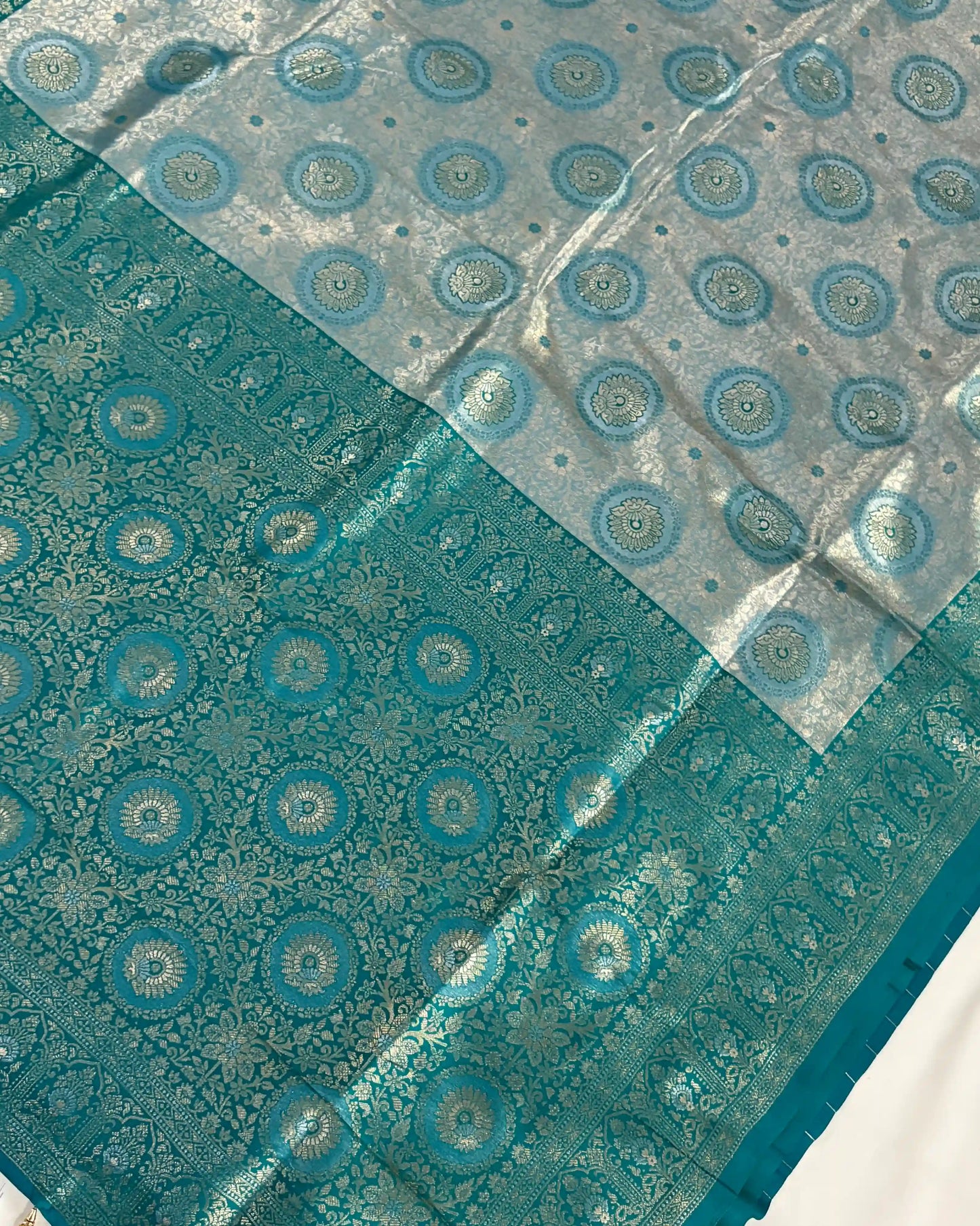 Teal fabric with circular patterns on a white background