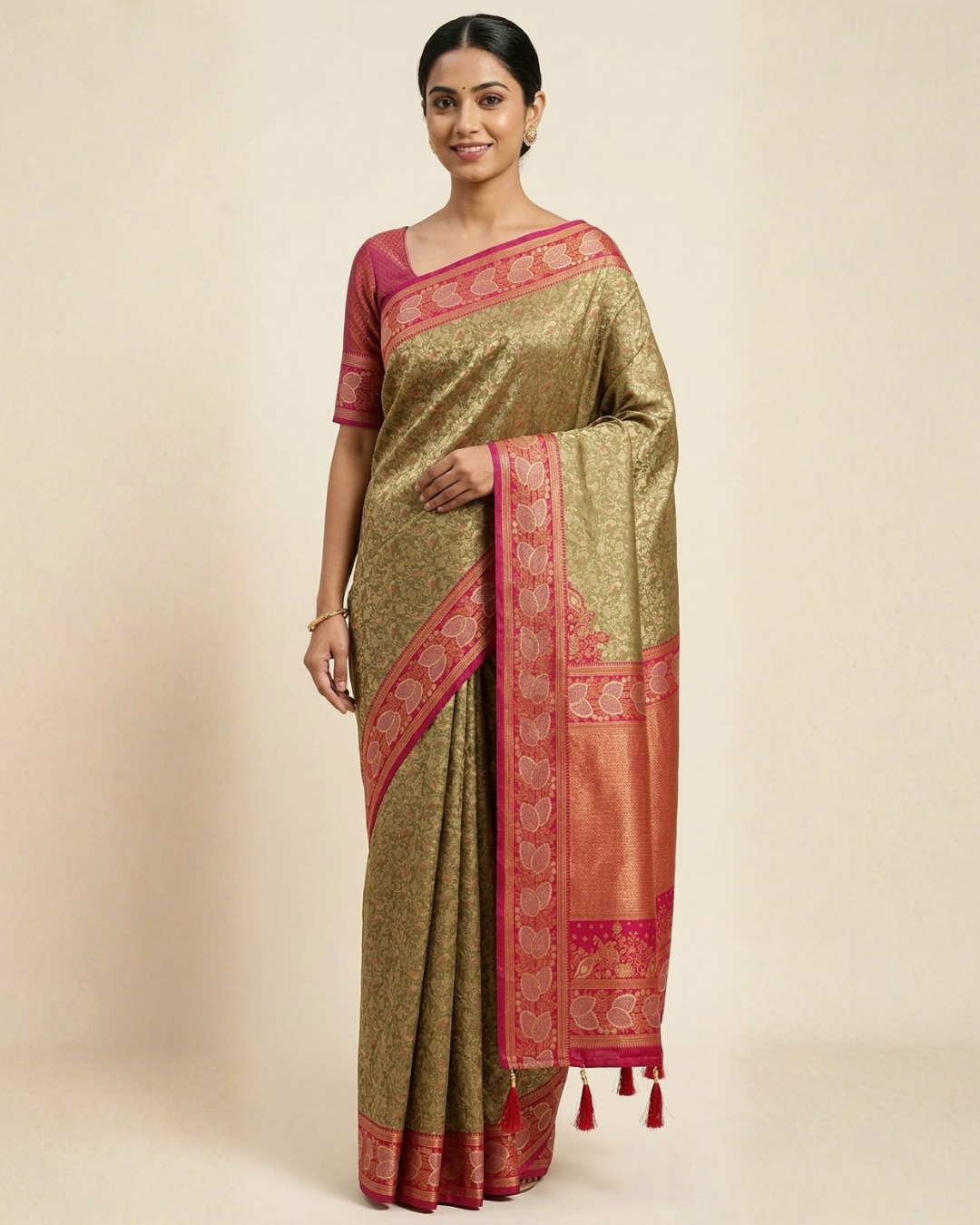 Woman wearing a traditional saree with a gold and red pattern on a beige background
