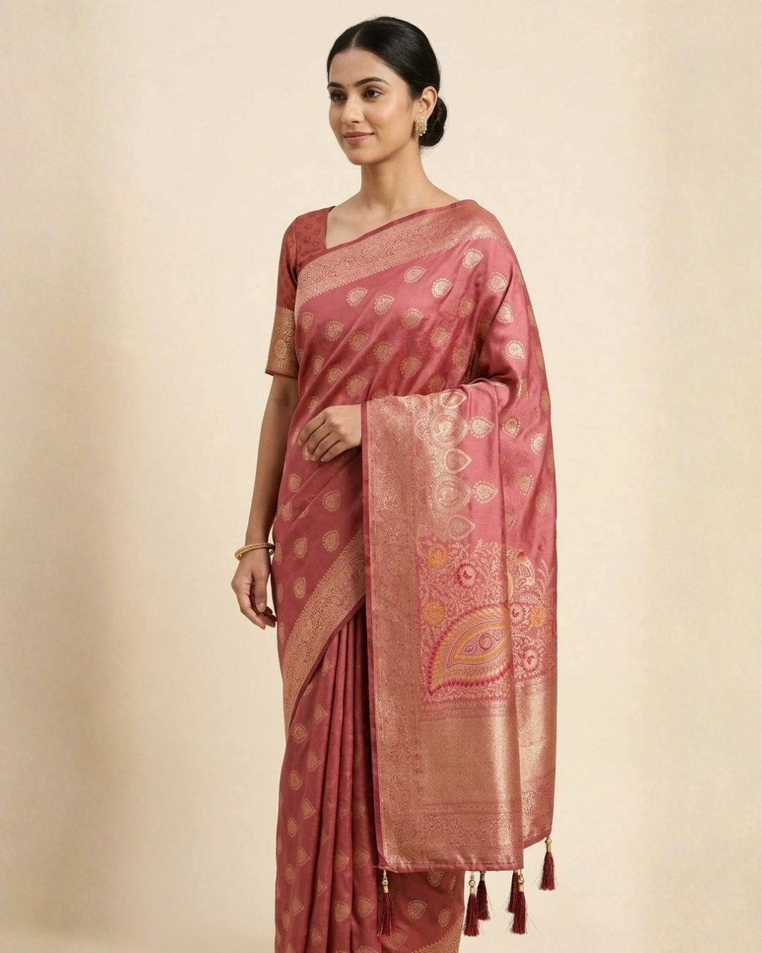 Woman wearing a pink saree with a subtle pattern on a beige background