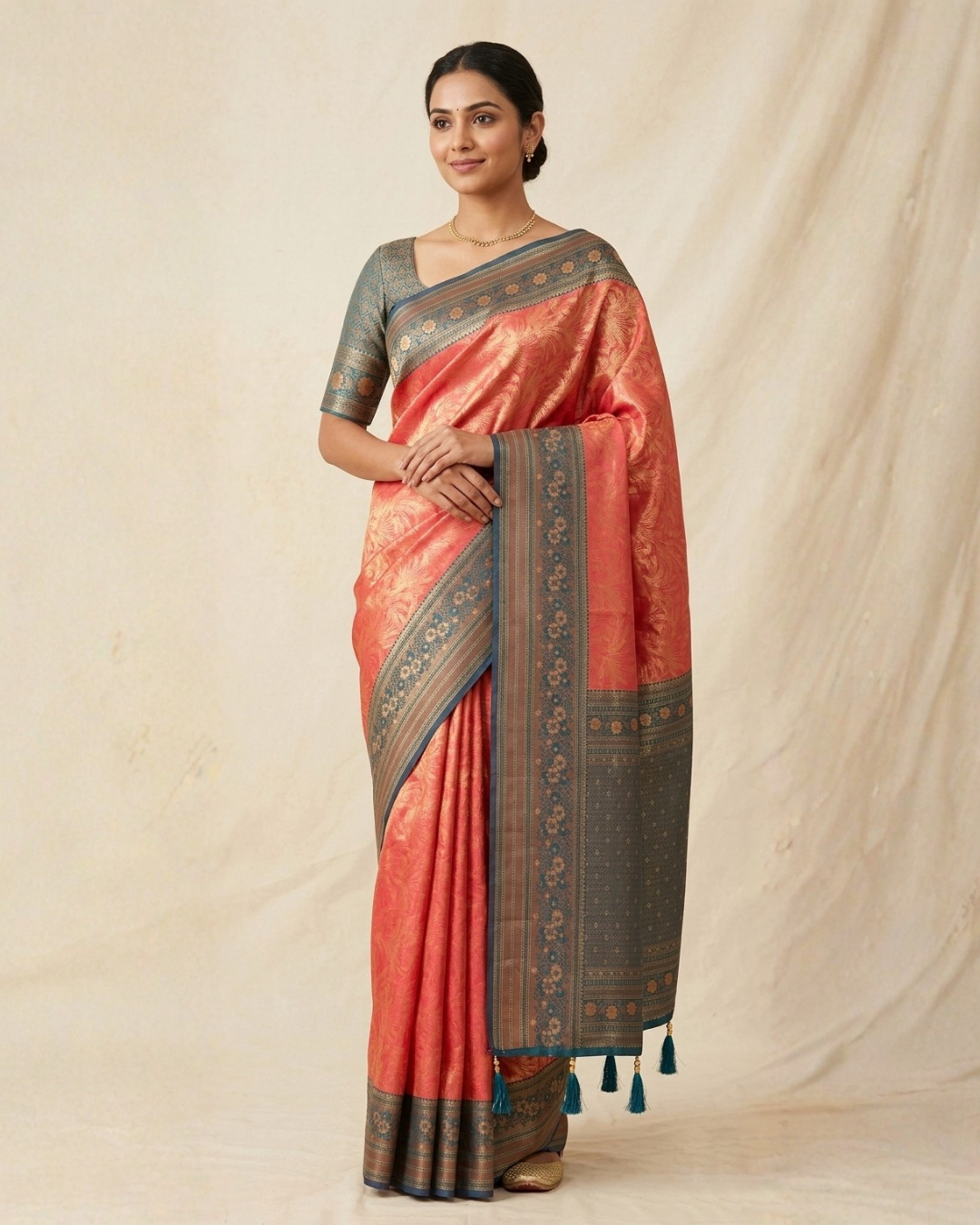 Woman wearing a traditional saree with a red and gold pattern on a beige background